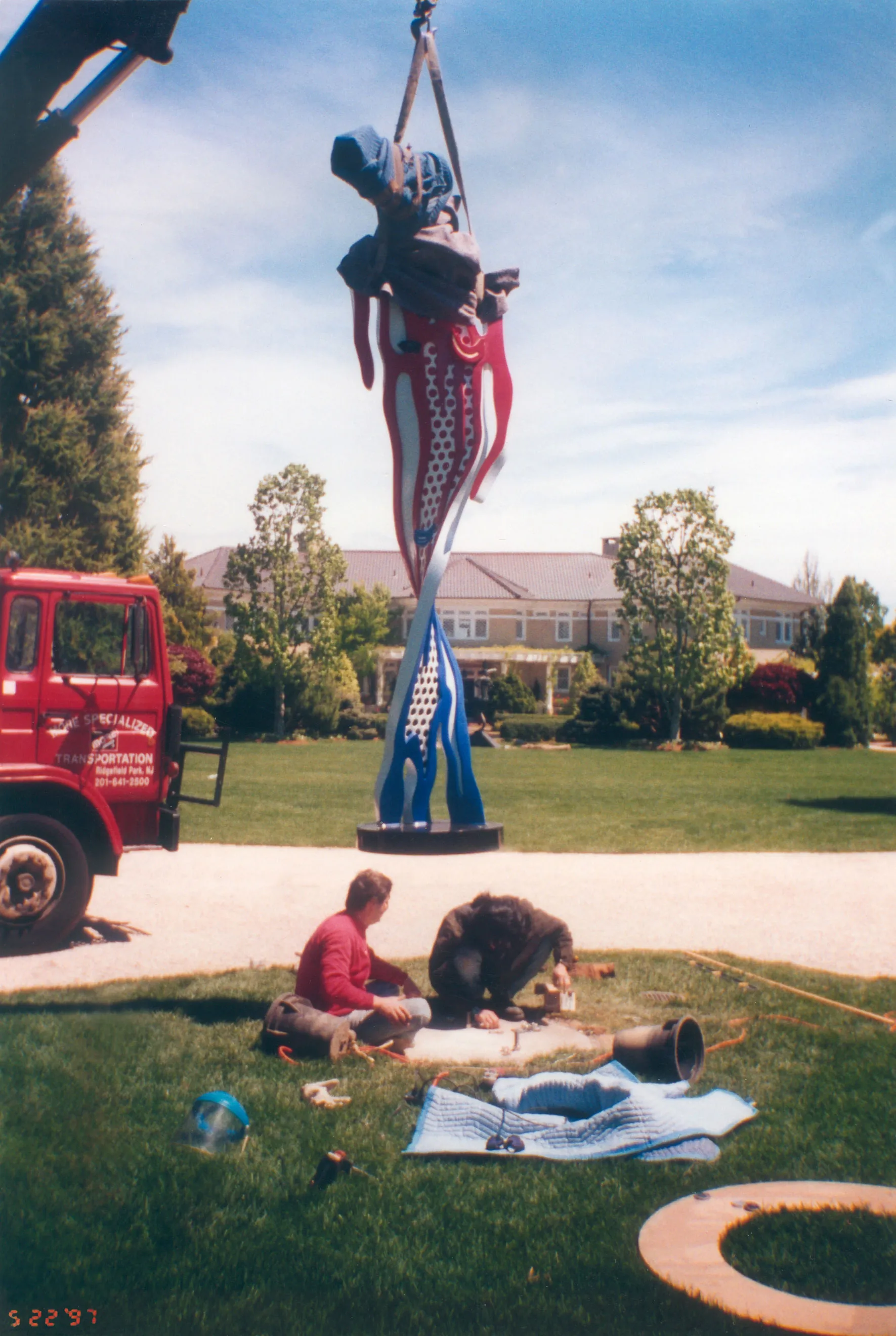 Crane-lifting painted sculpture onto estate lawn